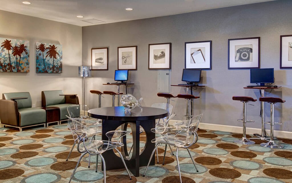 a room with a table and chairs and paintings on the wall