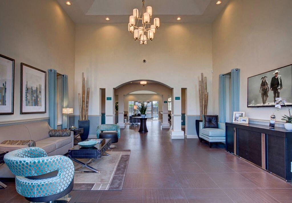 a lobby with couches and chairs and a chandelier