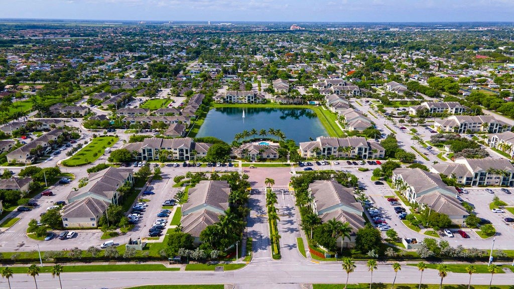 an aerial view of a neighborhood with a lake and parking lot