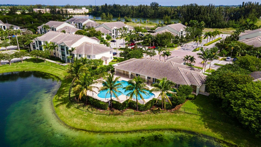 an aerial view of a resort with a pool and palm trees
