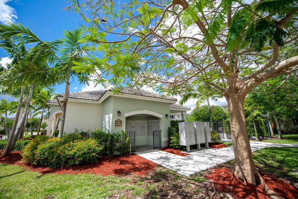 a house with a driveway and a tree in front of it
