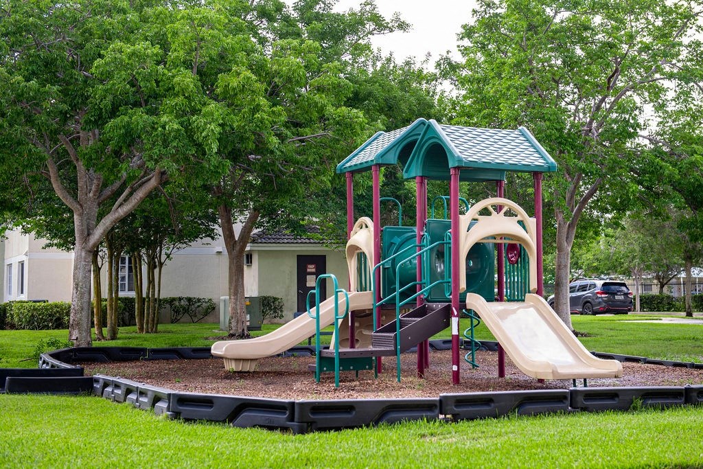 a playground with a set of slides in a park