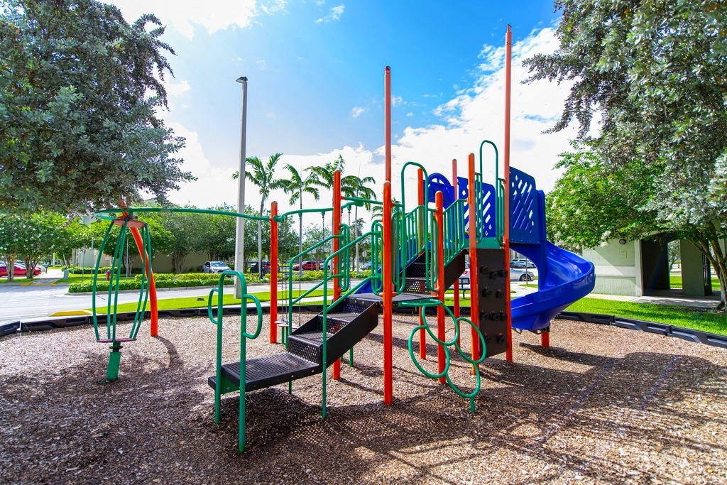 a playground with a blue and red slide and benches