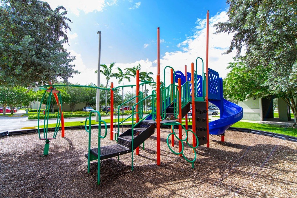 a playground with a blue and red slide and benches
