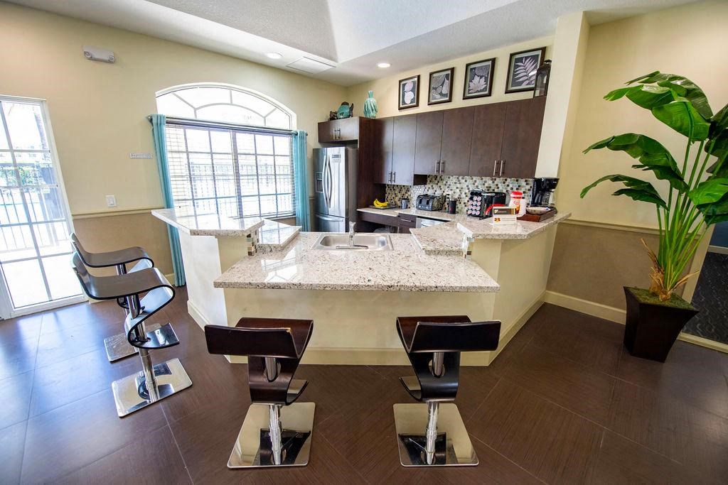 a kitchen with a bar and stools in front of a counter