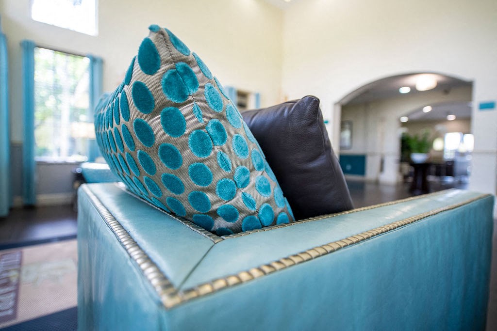 a blue couch with pillows on it in a living room
