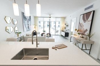 a kitchen with a sink and a view of a living room