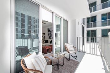 a living room with a couch and chairs on a balcony