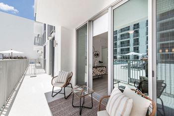 a living room with a balcony and a view of the ocean