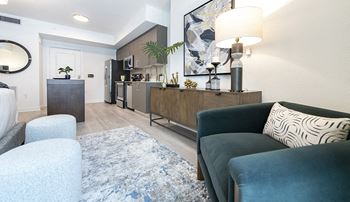 a living room with a couch and a chair and a kitchen