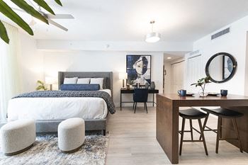 a bedroom with a bed and a desk and a living room