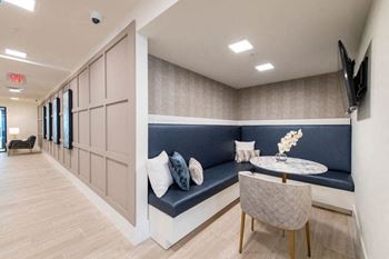 A long hallway with a bench and a television mounted on the wall.