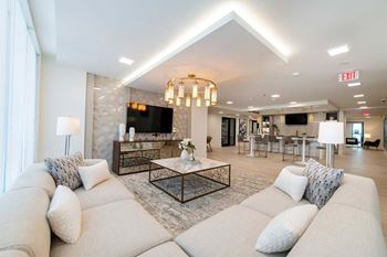 A living room with a white couch and a chandelier.
