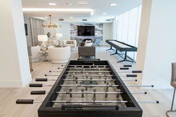 A foosball table is in the middle of a living room.