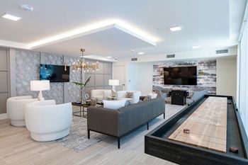 A modern living room with a pool table and a television.