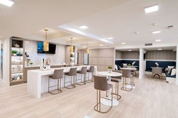 A modern dining area with a bar and chairs.