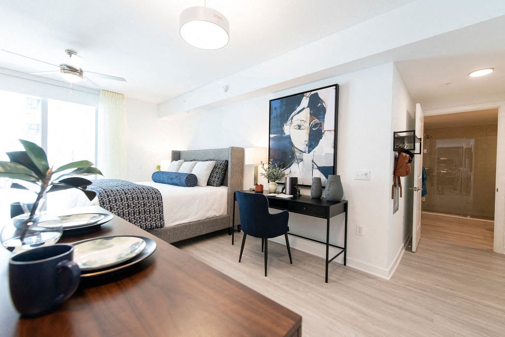 a bedroom with a bed and a desk in a room