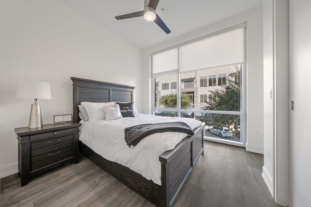 a bedroom with a large window and a bed