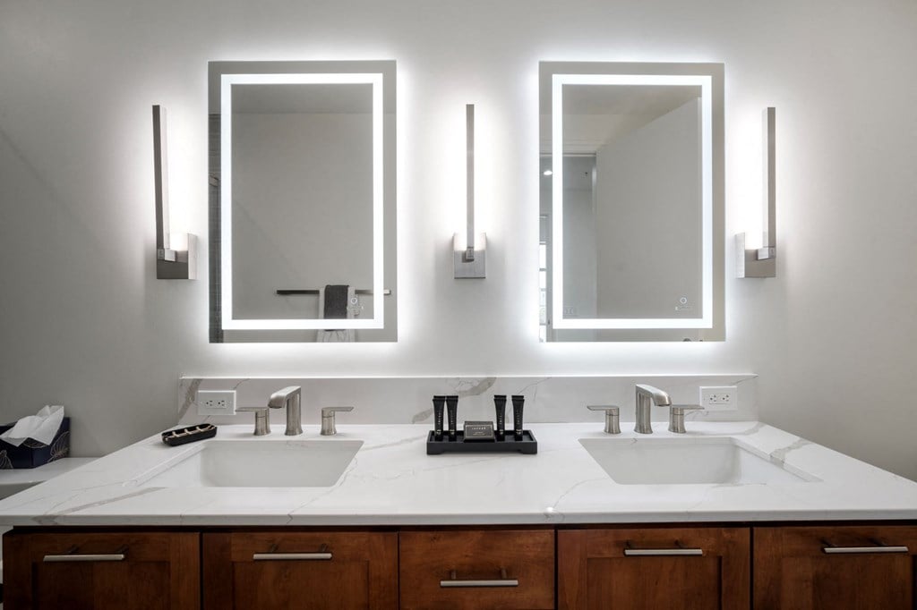 a bathroom with two sinks and two mirrors