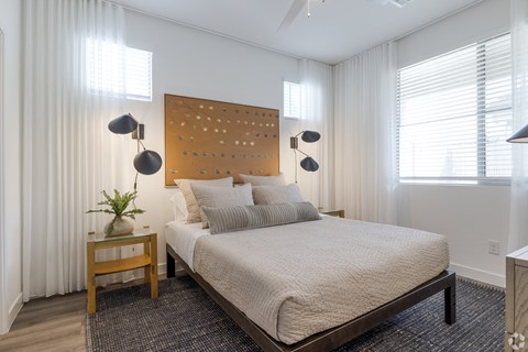 a bedroom with a large bed and white curtains
