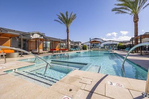 a swimming pool with palm trees and buildings in the background