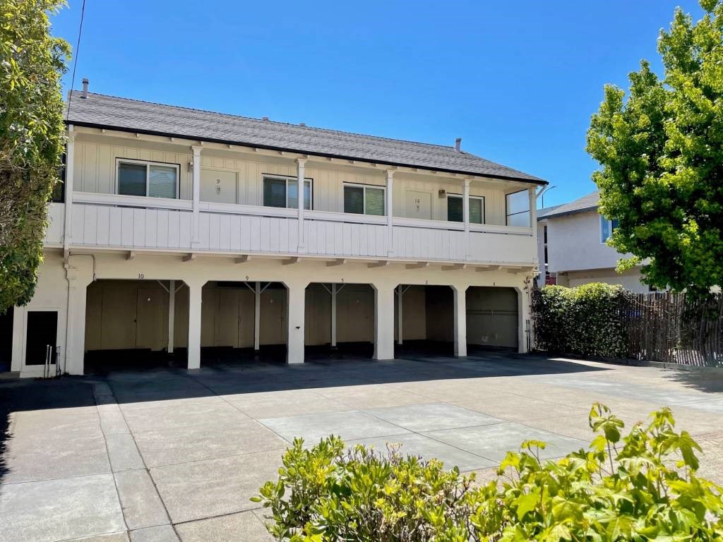 a large white house with a parking lot