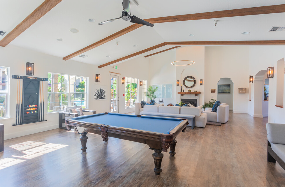 a large living room with a pool table in the middle