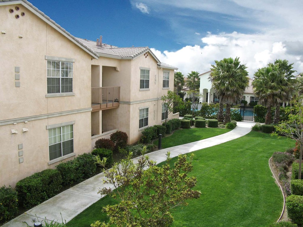 our apartments are located in the community with a green lawn and palm trees