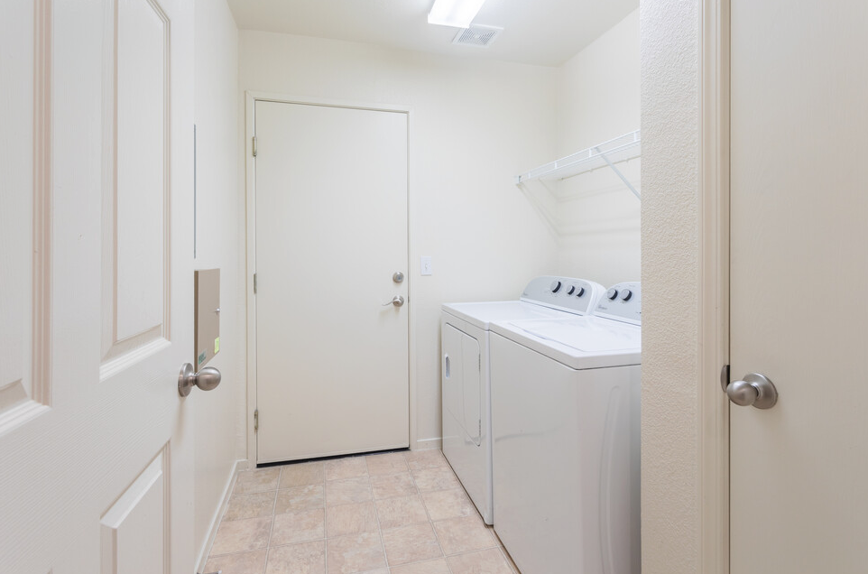 a laundry room with a washer and dryer and a door to a closet