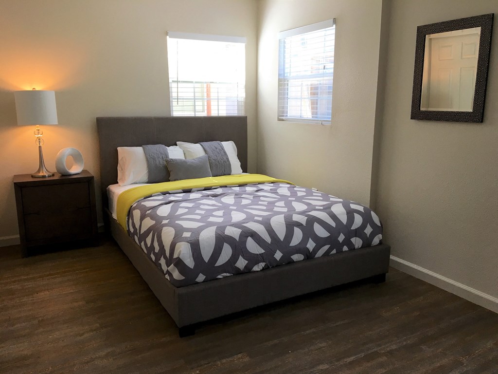 a bedroom with a bed and two windows