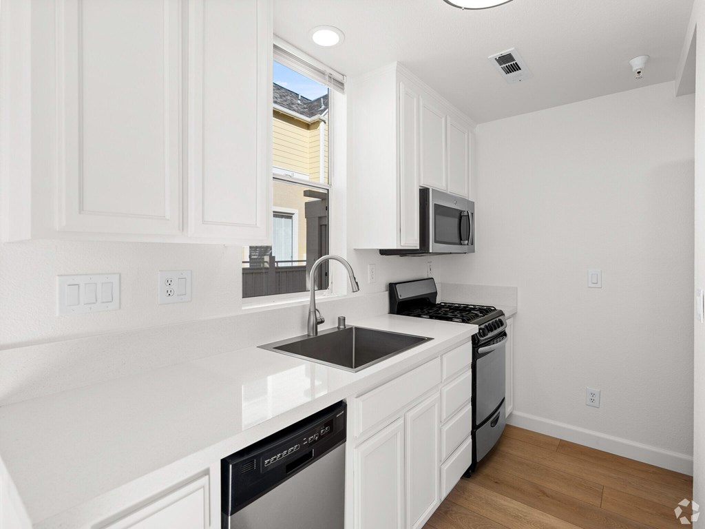 A kitchen with white cabinets and black appliances. at Westmont Place Townhomes Apartments, Santa Cruz, 95060