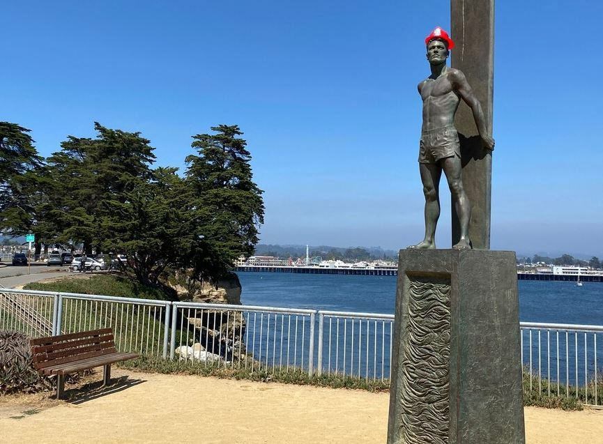 A statue of a man stands on a pedestal by the water at Westmont Place Townhomes Apartments, California