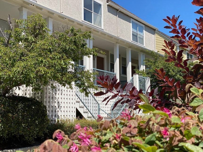 A white building with a balcony and a white picket fence at Westmont Place Townhomes Apartments, Santa Cruz, California