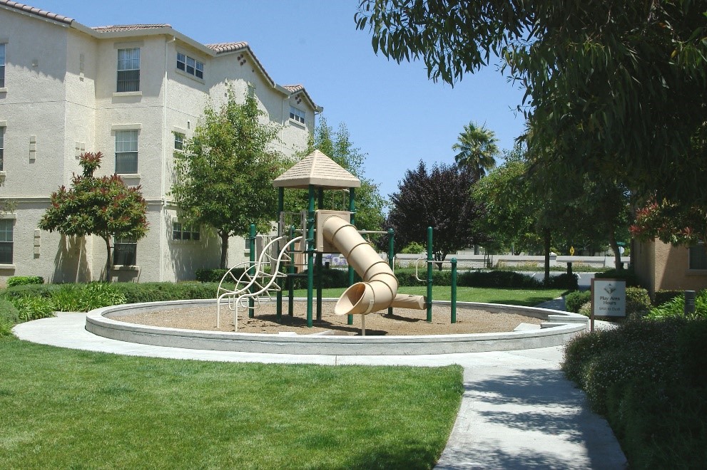 a playground in a park in front of an apartment building