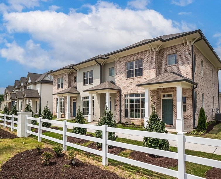 townhomes building with a white fence in front of it