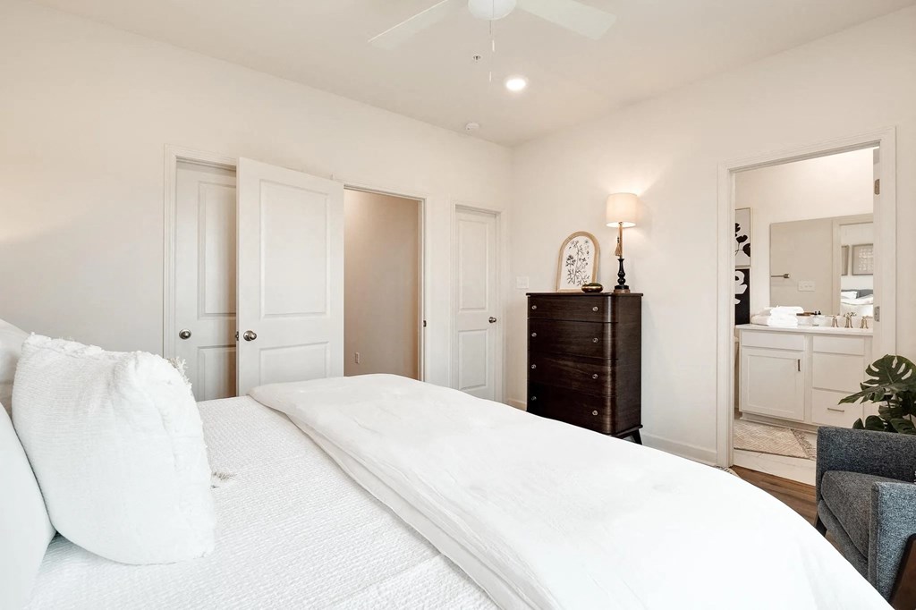 a white bedroom with a large bed and a closet
