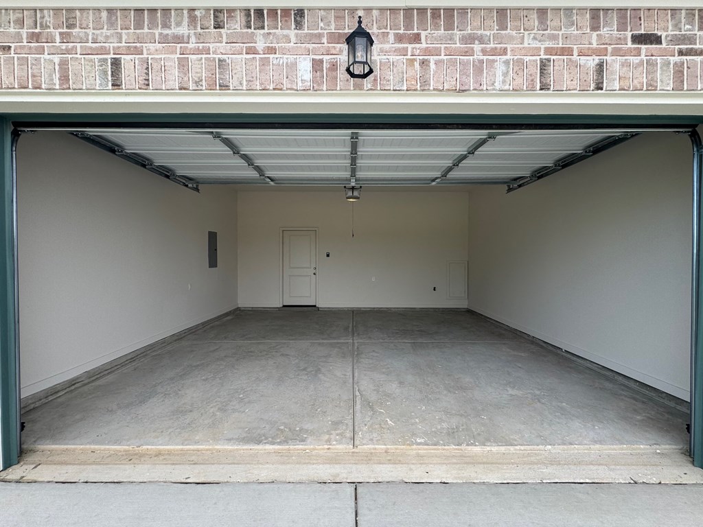 the inside of a garage with a concrete floor and a brick wall