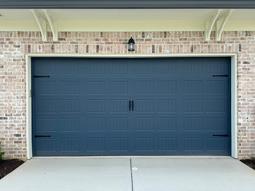 a blue garage door on a brick building