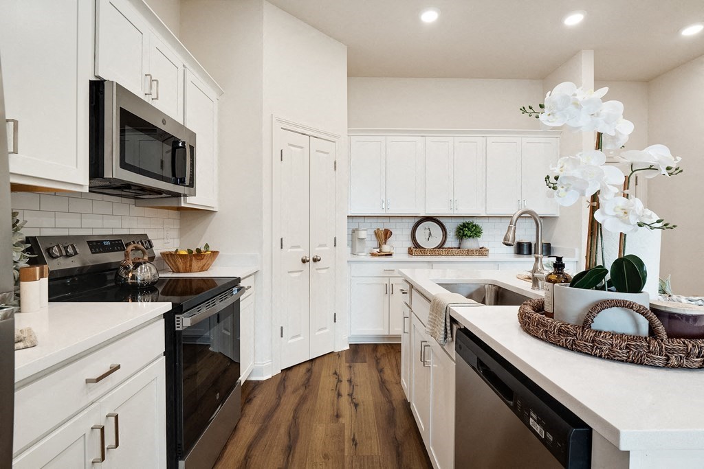 a kitchen with white cabinets and stainless steel appliances