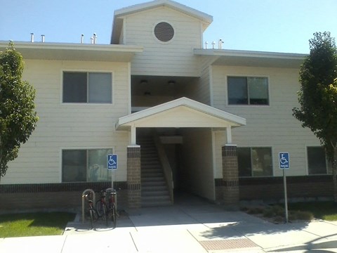 the front of a white building with two bikes parked in front