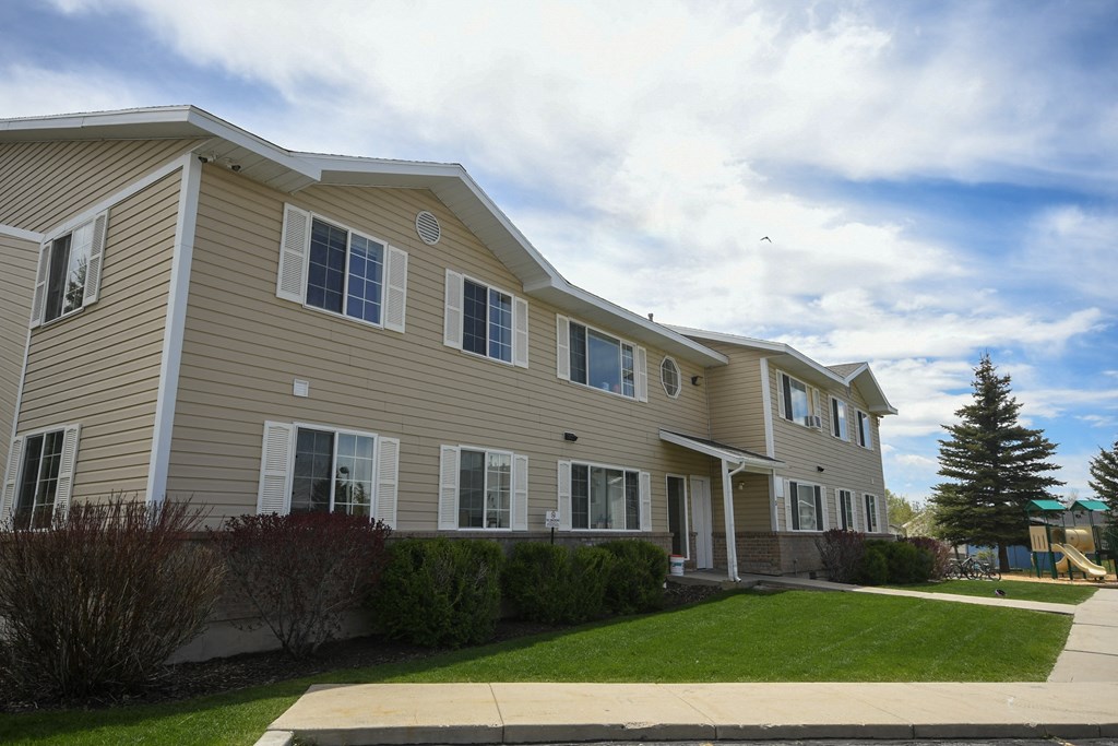 a tan house with a sidewalk in front of it