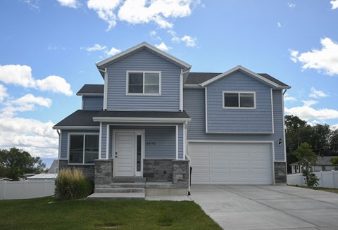 a blue house with a driveway and a white garage door