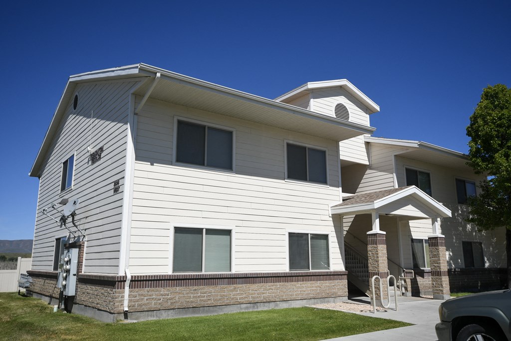 the front of a white house with a blue sky in the background