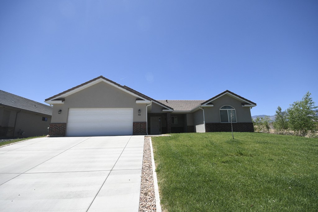 a house with a driveway and lawn in front of it