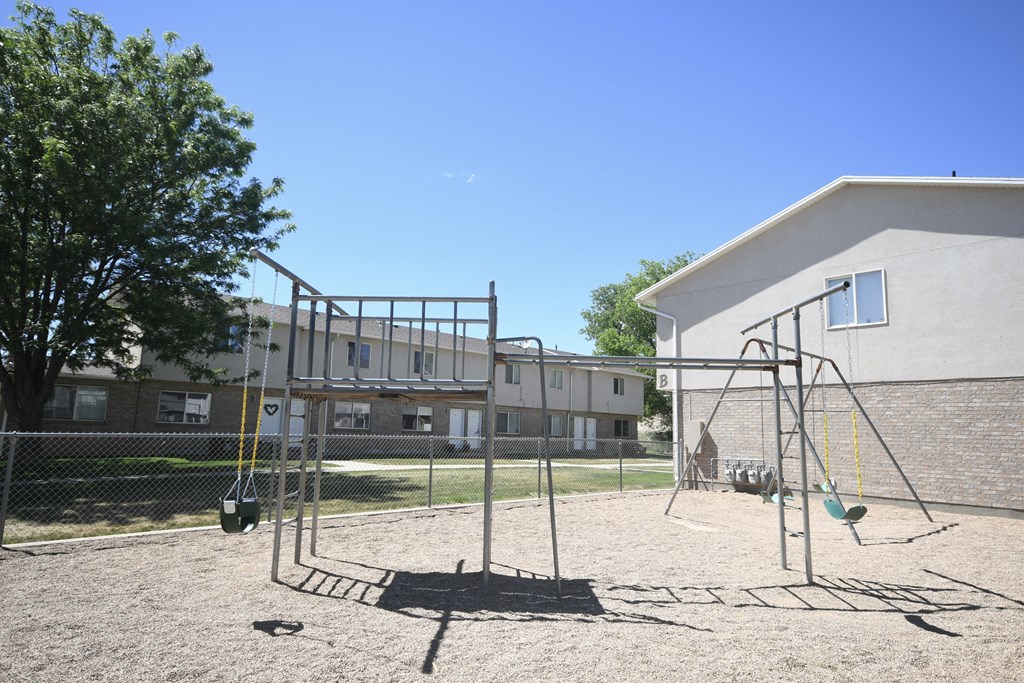 an empty playground in front of an apartment building