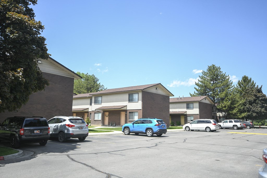 a parking lot with cars in front of an apartment building