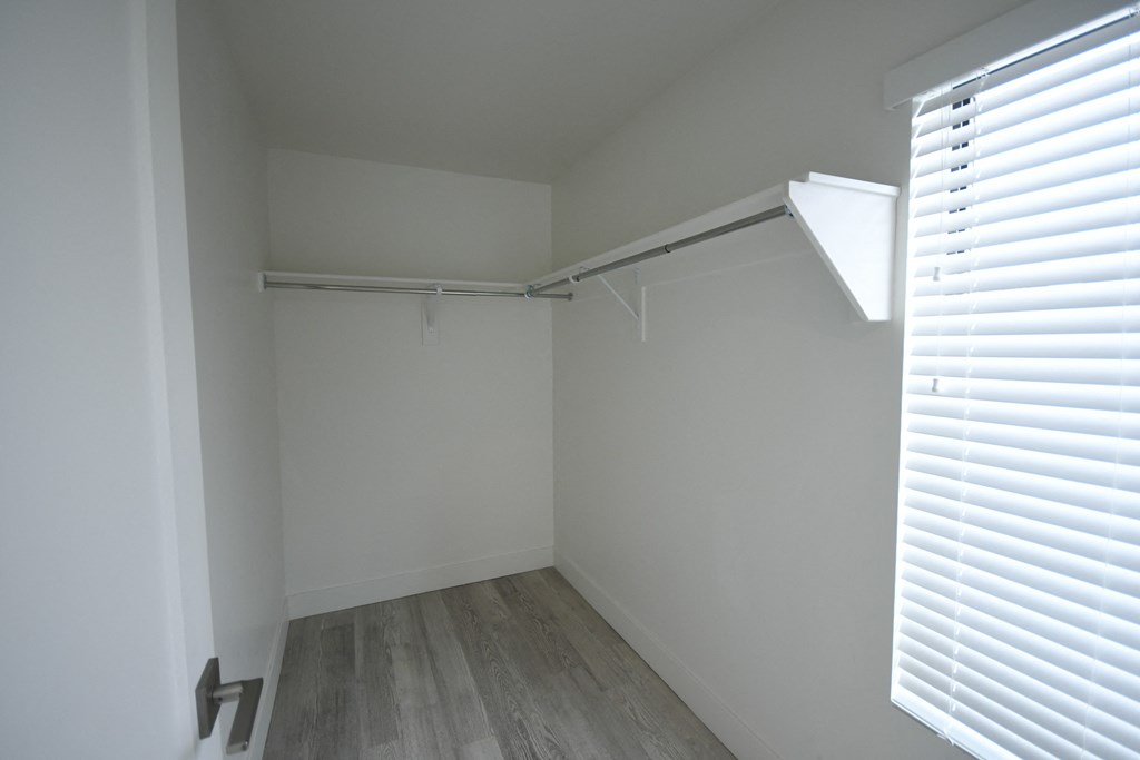an empty closet in a room with white walls and wood floors