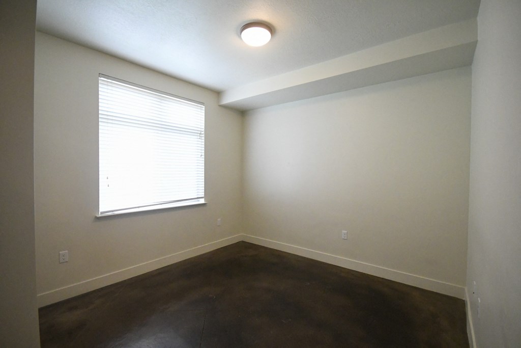 an empty room with a window and a carpet