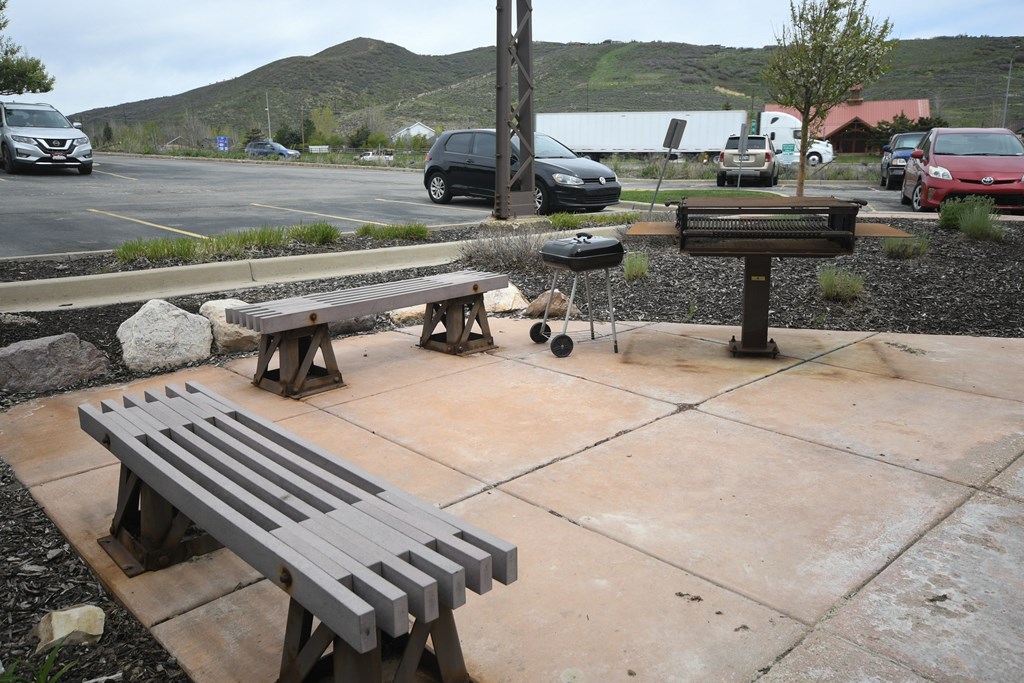 two benches sitting on a sidewalk next to a parking lot