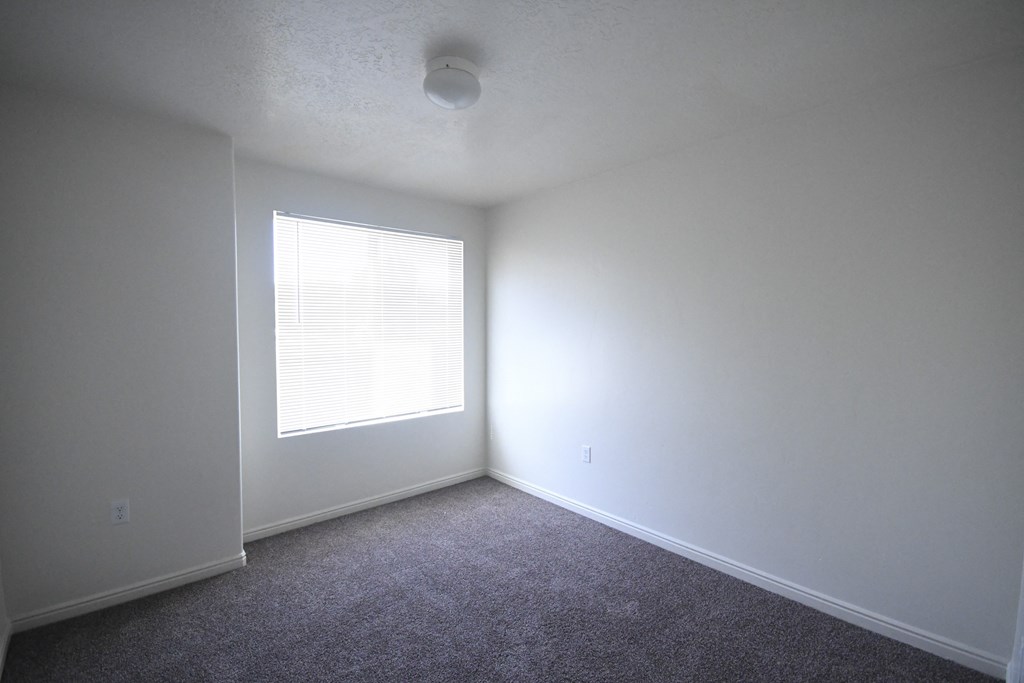 an empty room with white walls and a window